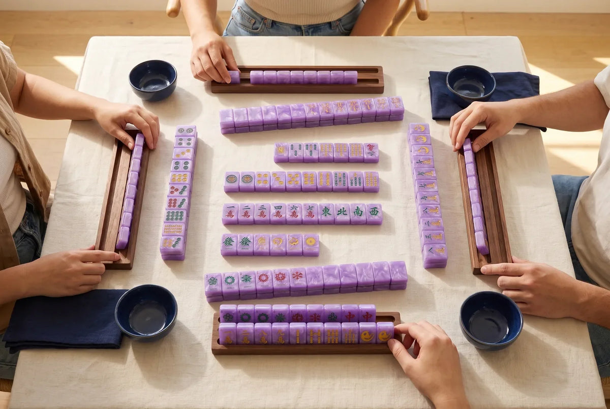 A complete mahjong set sorted into groups of tiles on a table, seen from above