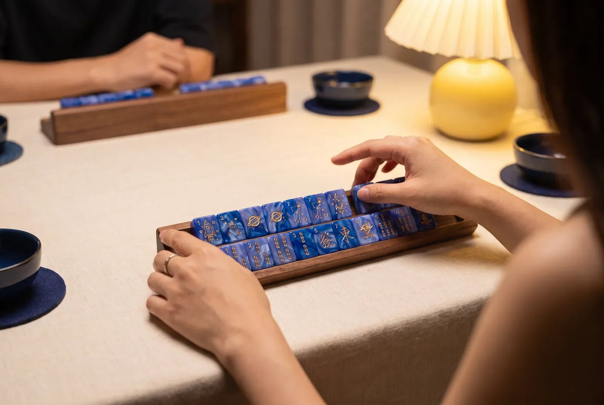 A player studies her rack of blue tiles and gets ready to discard