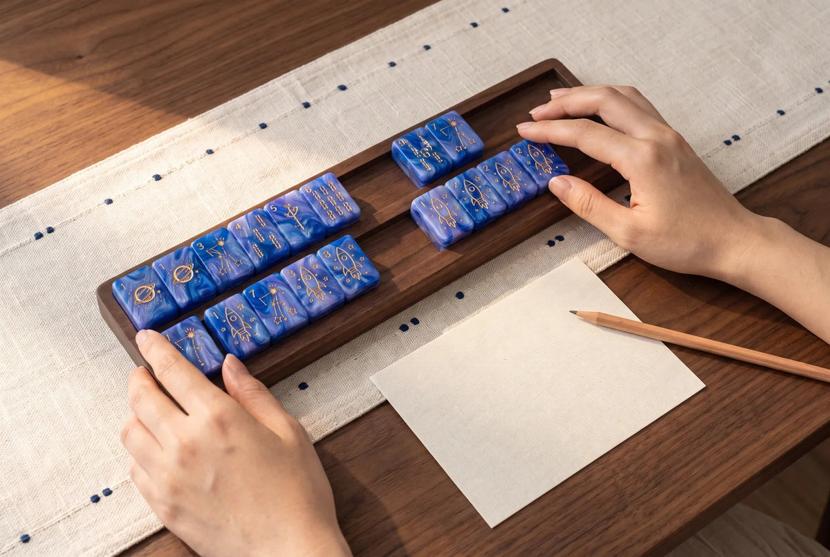 A player sorts blue mahjong tiles on her rack by color and number