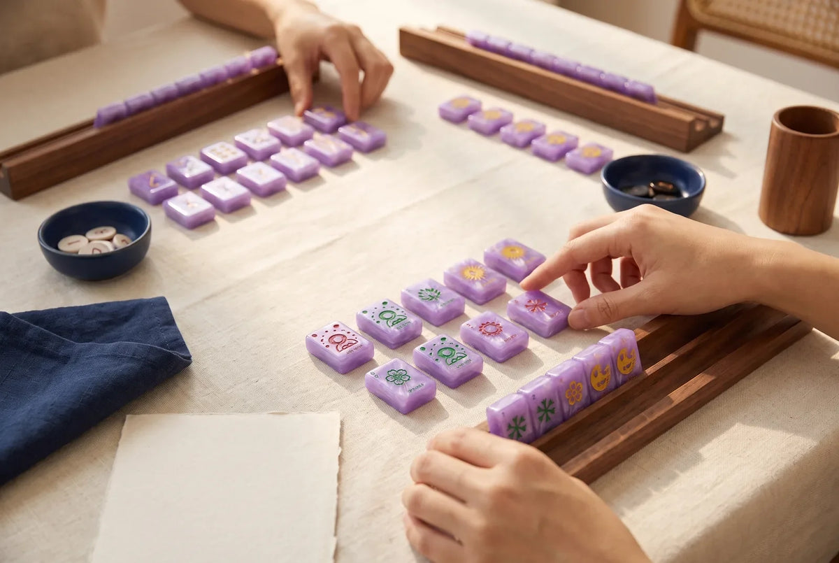Mahjong tiles sorted into small groups on linen, showing the different kinds of tiles